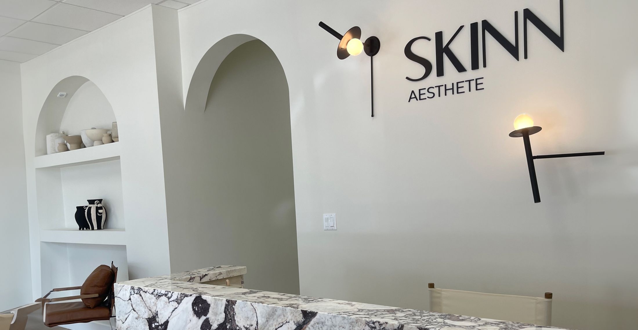 Modern aesthetic reception area with marble desk.